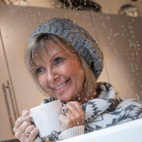 Woman in winter hat with warm cup of hot chocolate